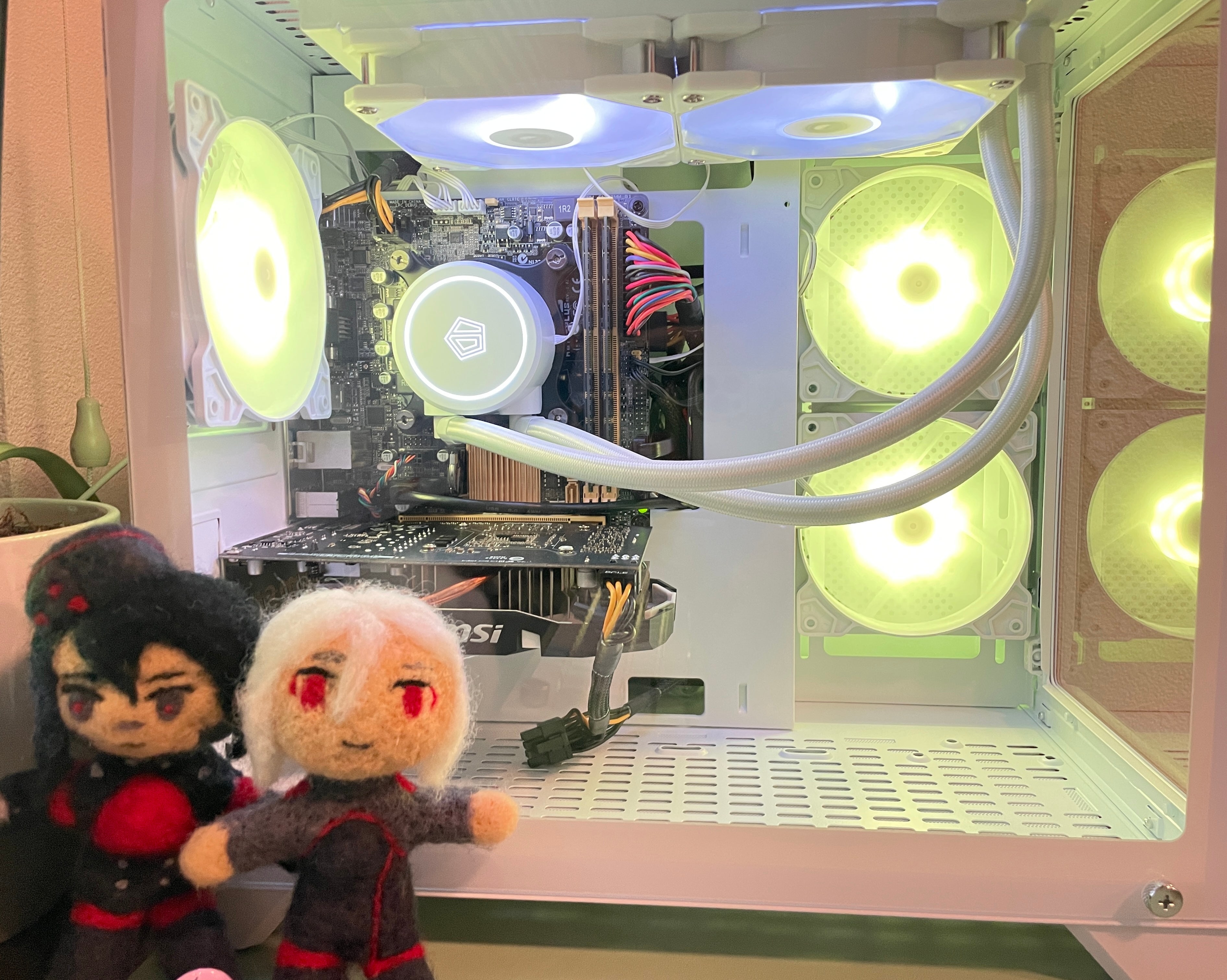 A close up of the PC. There are felted dolls of Elster and Ariane from Signalis in front of it.